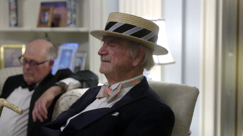 Mr. Fleming wearing a straw hat and listening to the music at Bellevue House.